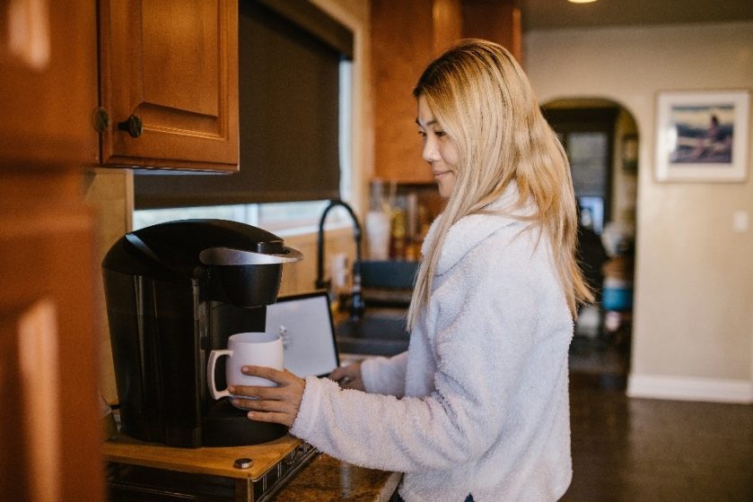 Girl Taking Out a Cup of Tea from Microwave
