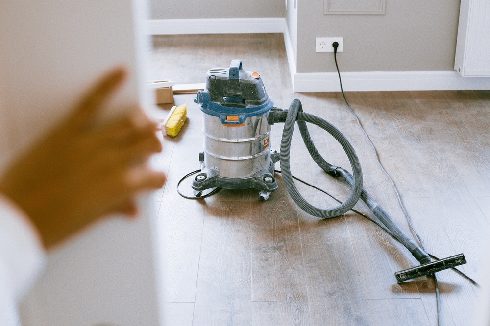 vacuum placed on wooden floor with brush